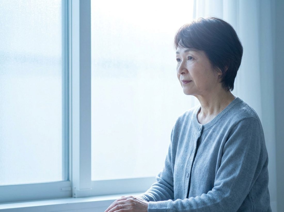 窓辺で考えごとをする女性
